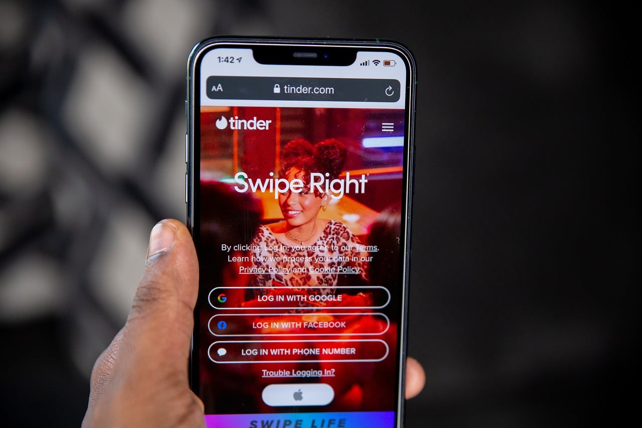 Smartphone mit der Startseite der App Tinder.